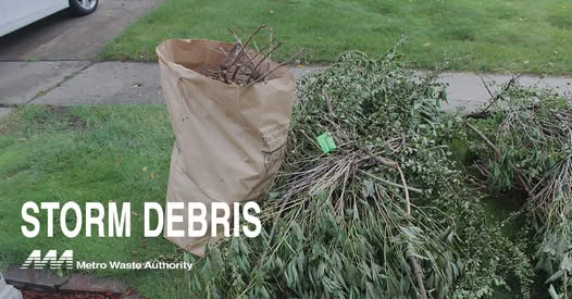 Photo of brush bundles and bagged yard waste at the curb after a storm.